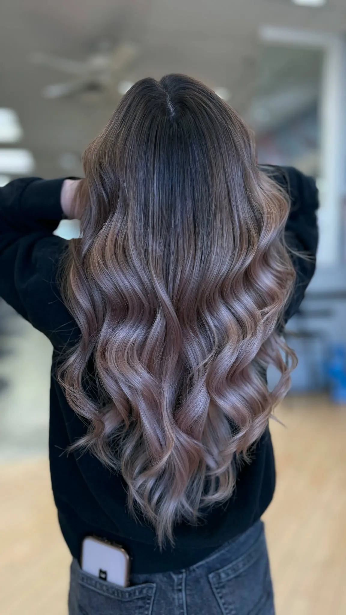 Cabello largo ondulado con raíz castaña que se funde en balayage rosa y rubio