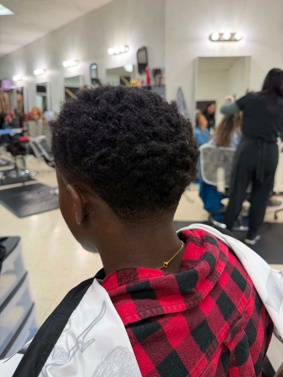 Afro redondeado de un niño con taper fade