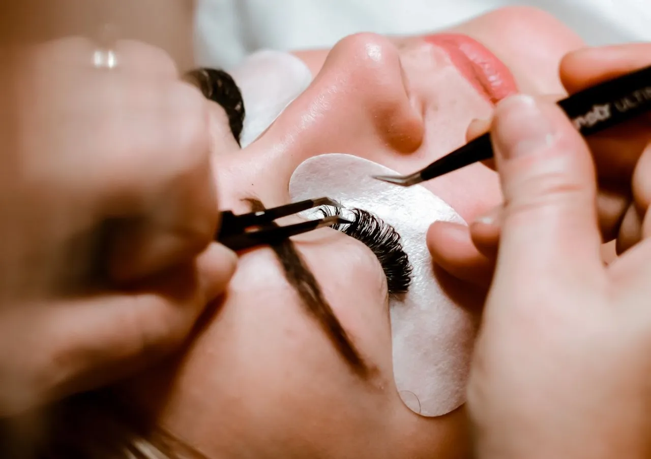 A lash artist applying eyelash extensions