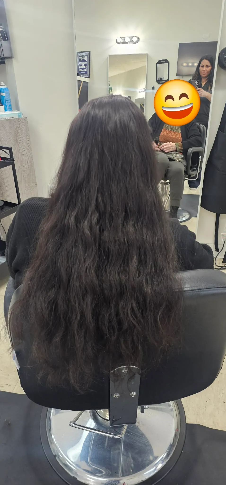 Cabello largo, oscuro y ondulado peinado en el sillón